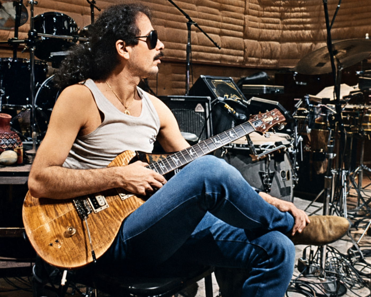 Carlos Santana seated with a PRS guitar in the studio live room