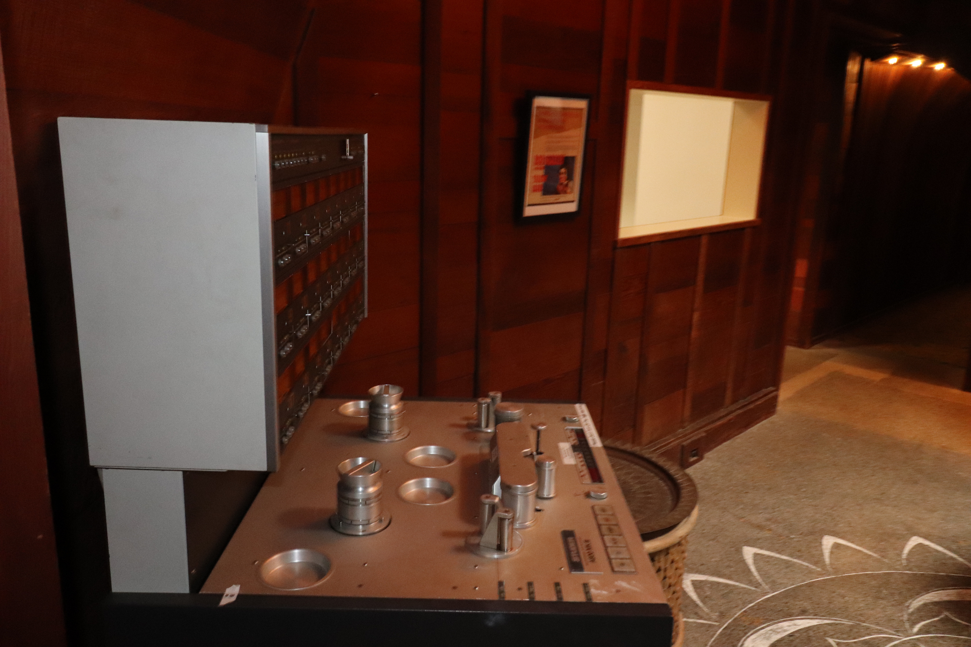 Vintage Studer reel-to-reel tape machine sitting in the redwood-paneled game room beside a framed poster.