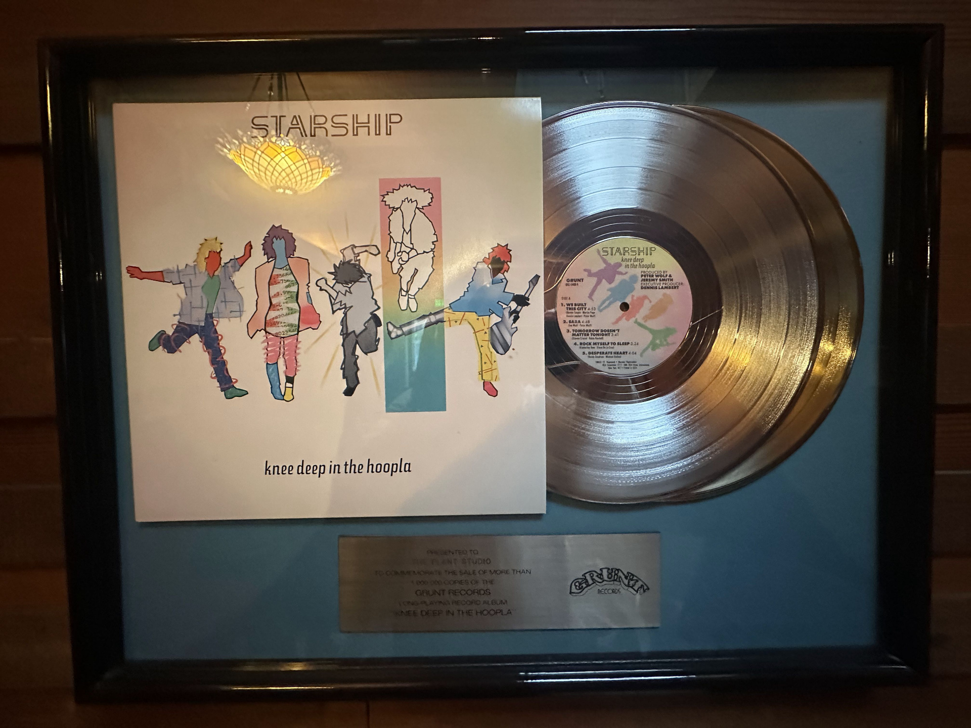 Framed platinum record award for Starship's Knee Deep in the Hoopla, presented to The Plant Studio by Grunt Records, hanging on the redwood-paneled game room wall.