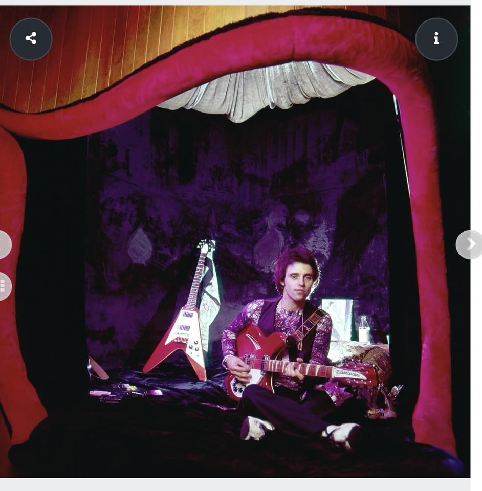 Nils Lofgren seated on the bed in the Pit at Record Plant Sausalito beneath the red velvet draped archway.