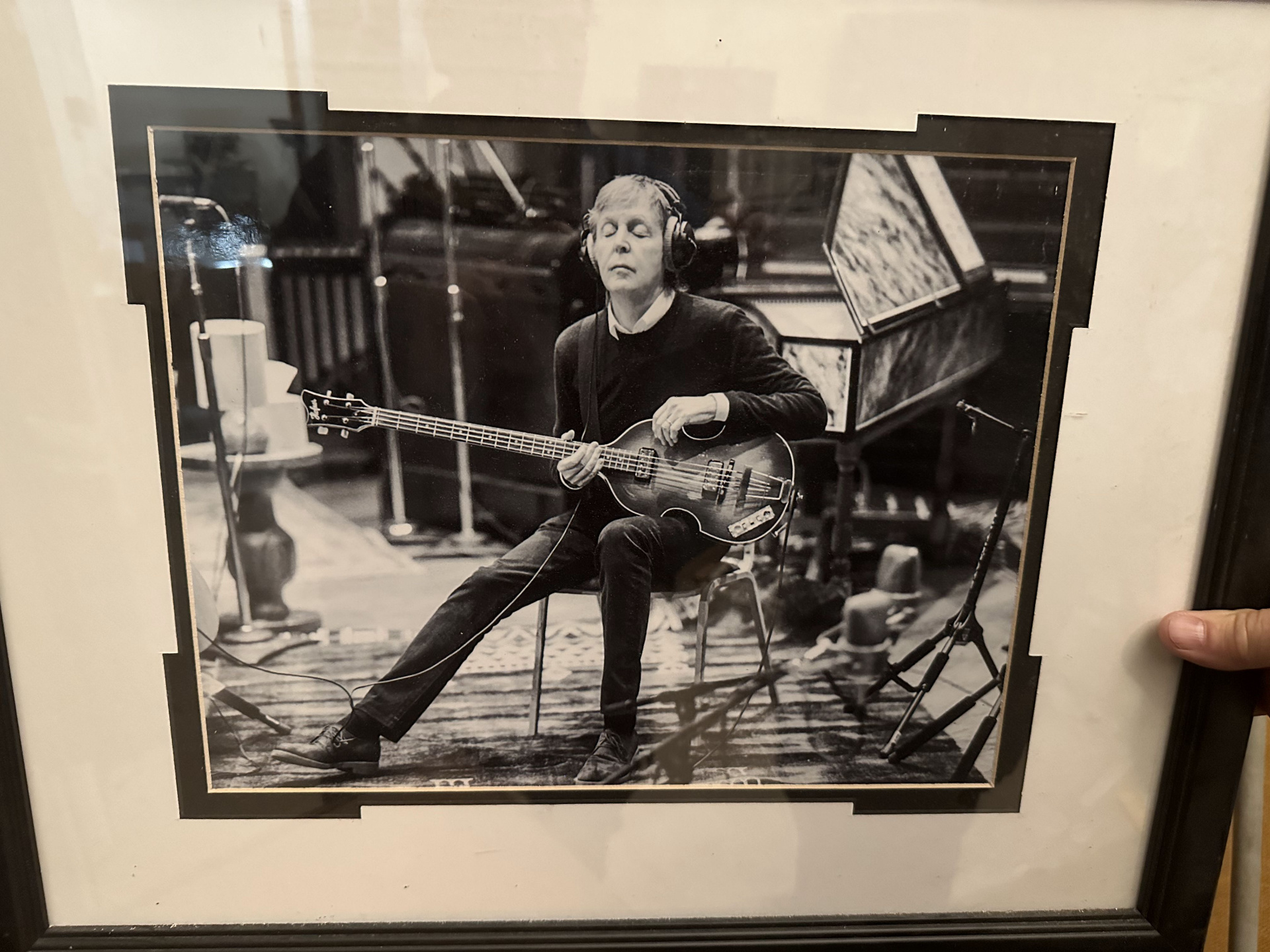 Framed black-and-white photograph of Paul McCartney playing his Höfner bass in a recording studio, eyes closed.