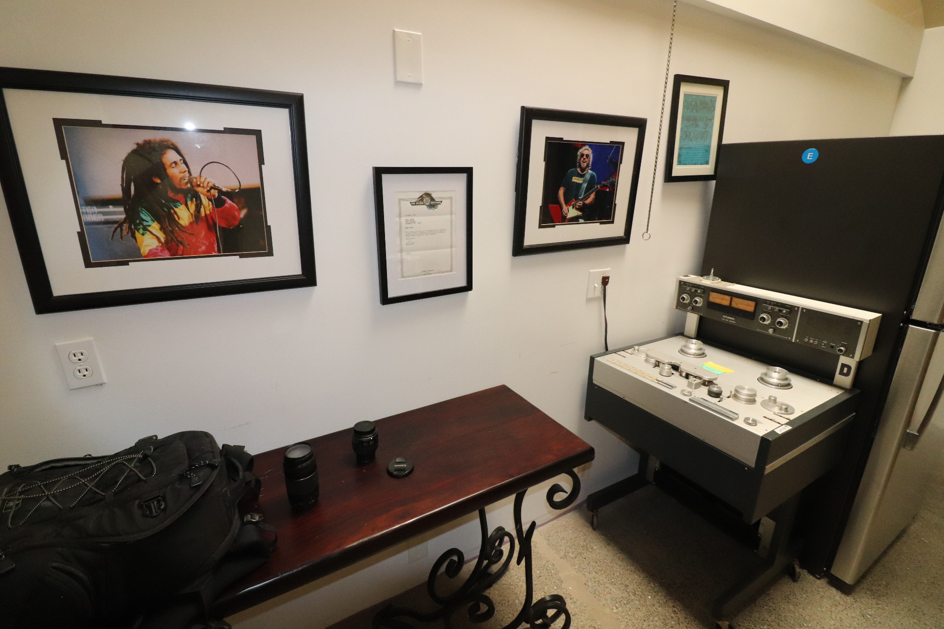 The old kitchen area at 2200 Studios — a framed photo of Bob Marley singing into a microphone, a Doobie Brothers letter, a framed photo of Sammy Hagar, and a vintage Studer reel-to-reel tape machine against a white wall.