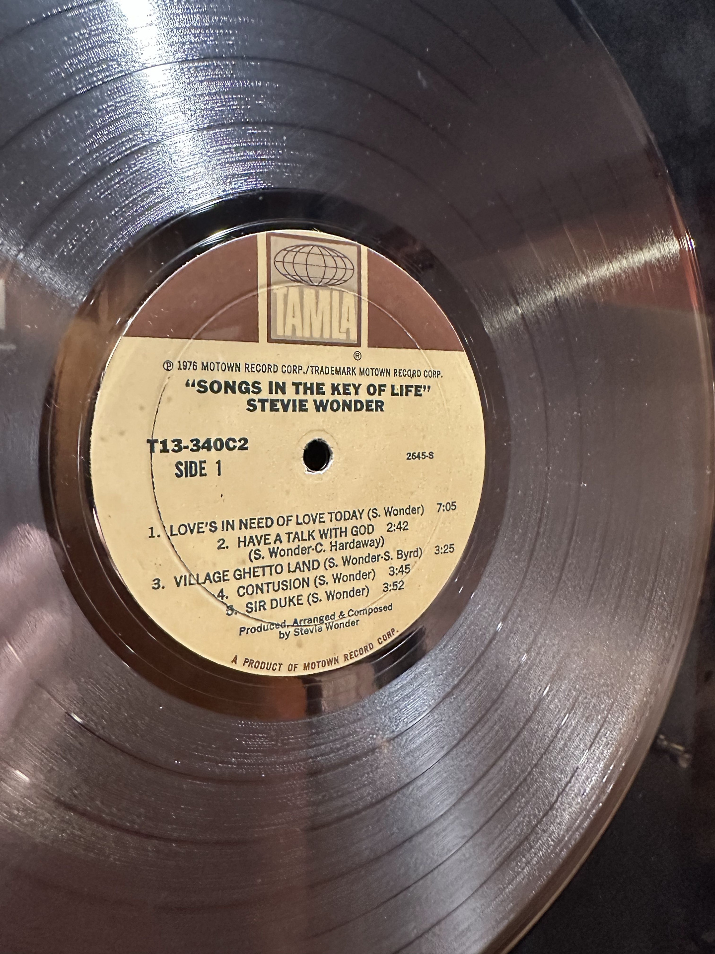 Close-up of a Tamla Records vinyl pressing of Stevie Wonder's Songs in the Key of Life, side 1, listing Sir Duke and Love's in Need of Love Today.