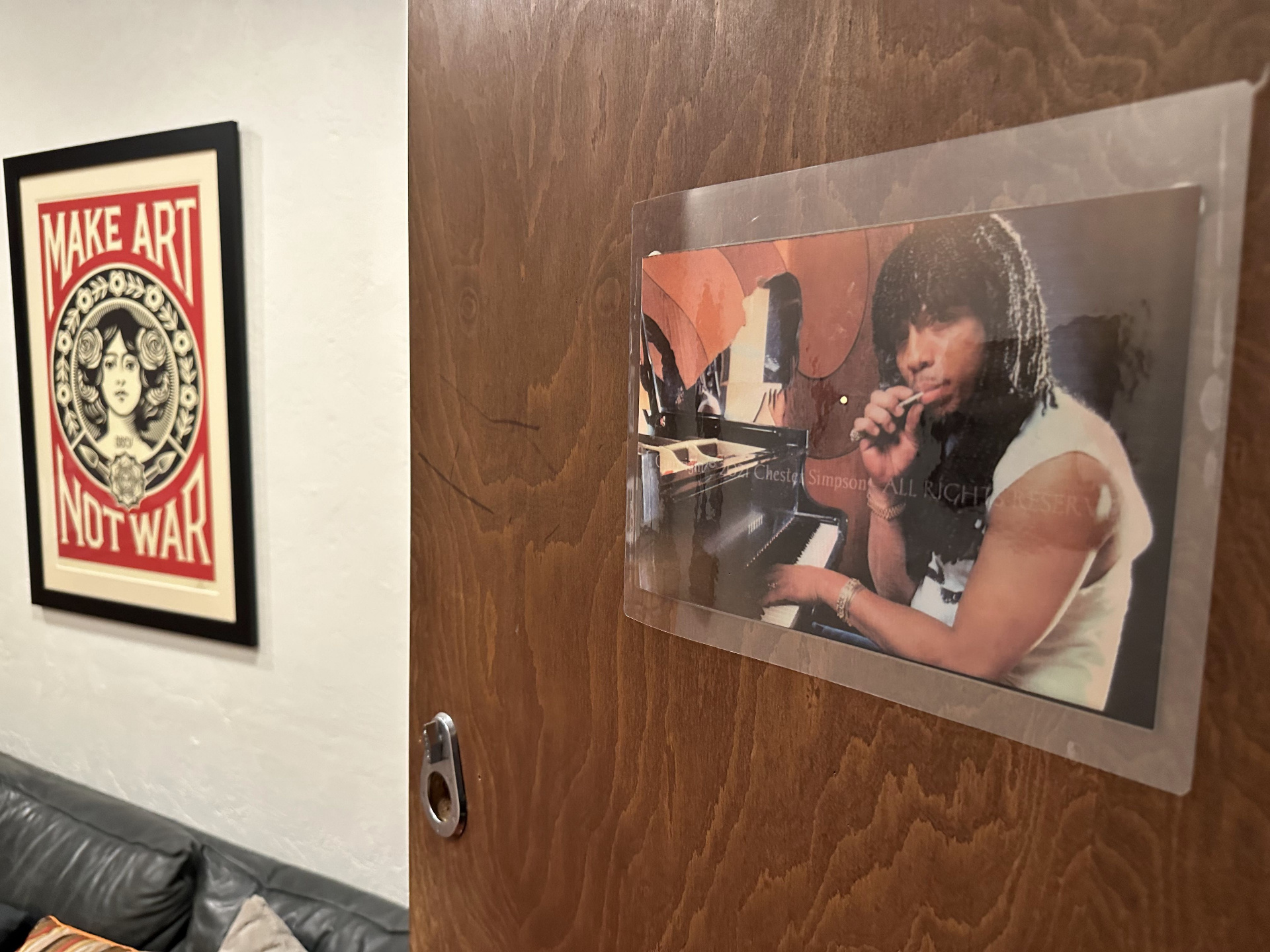 The wooden door of Rick James's former conference room at 2200 Studios, with a photograph of him at a grand piano mounted on it.