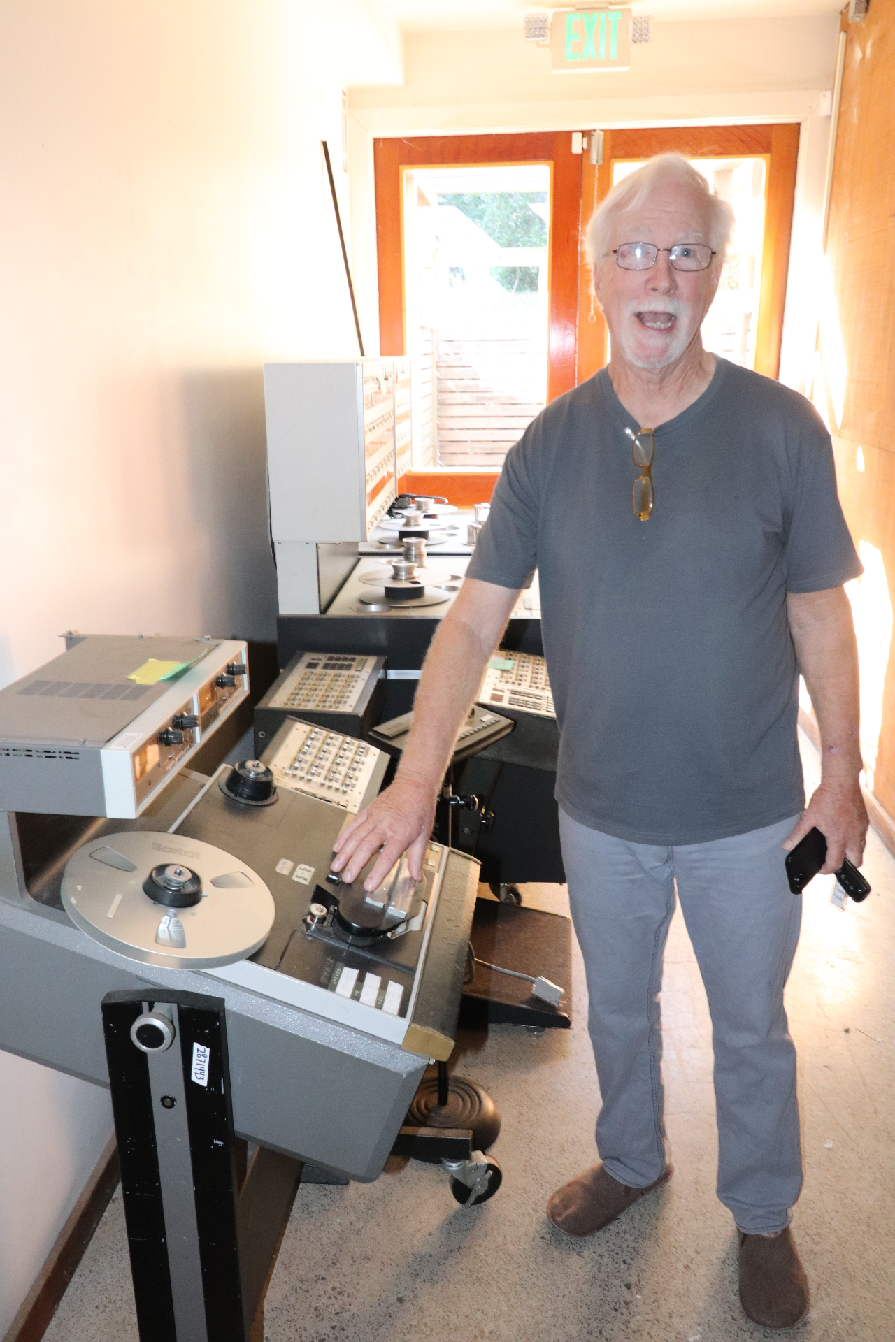 Ron Garrett standing beside vintage Studer reel-to-reel tape machines in the back area of 2200 Studios.