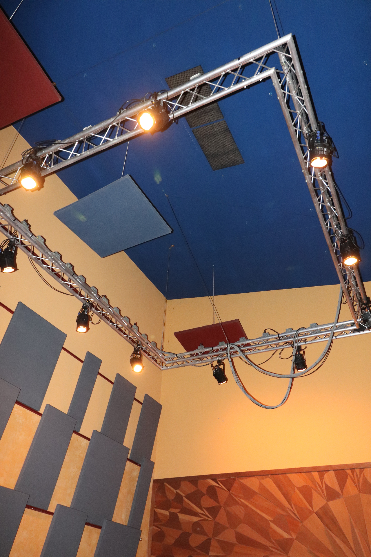 Lighting truss and acoustic panels under Studio A's raised blue ceiling