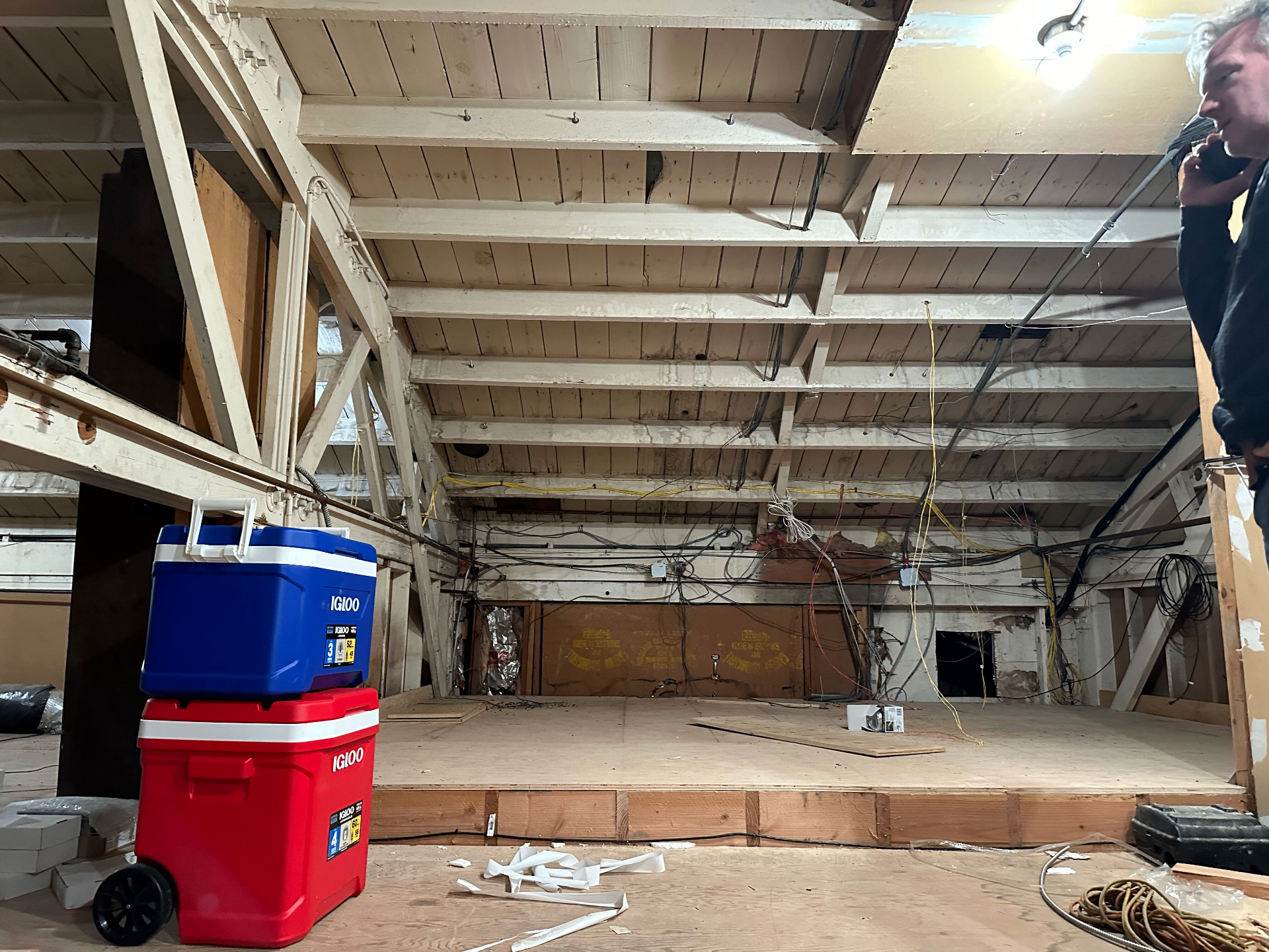 The studio attic above the Garden, with exposed wooden ceiling beams, tangled wiring, and construction materials during restoration