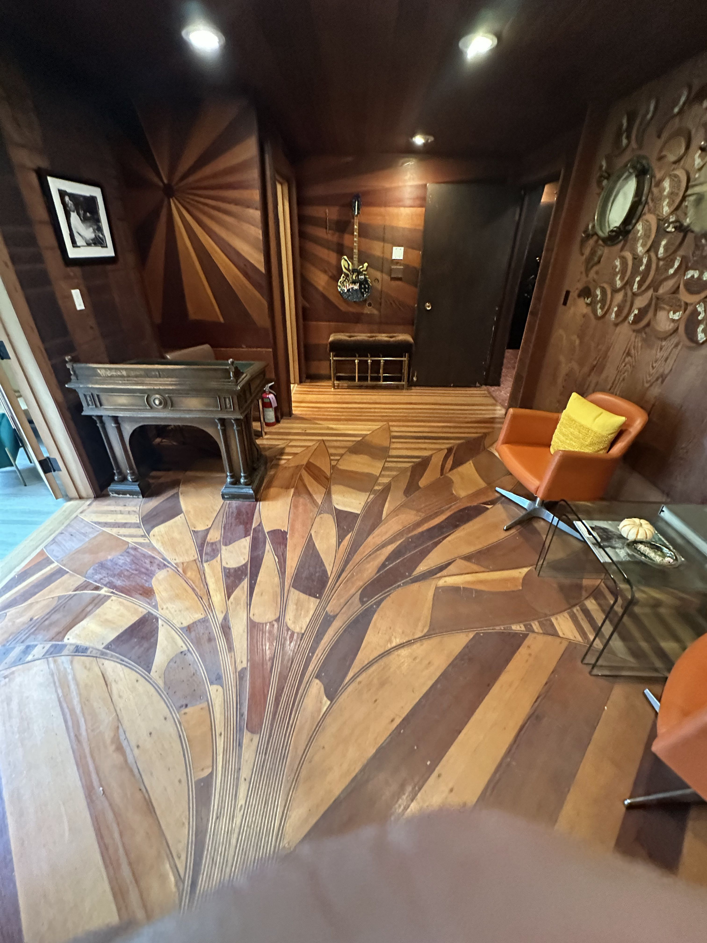 Lobby of the Record Plant Sausalito with elaborate inlaid wooden floor, sunburst paneled walls, and a guitar mounted by the door.