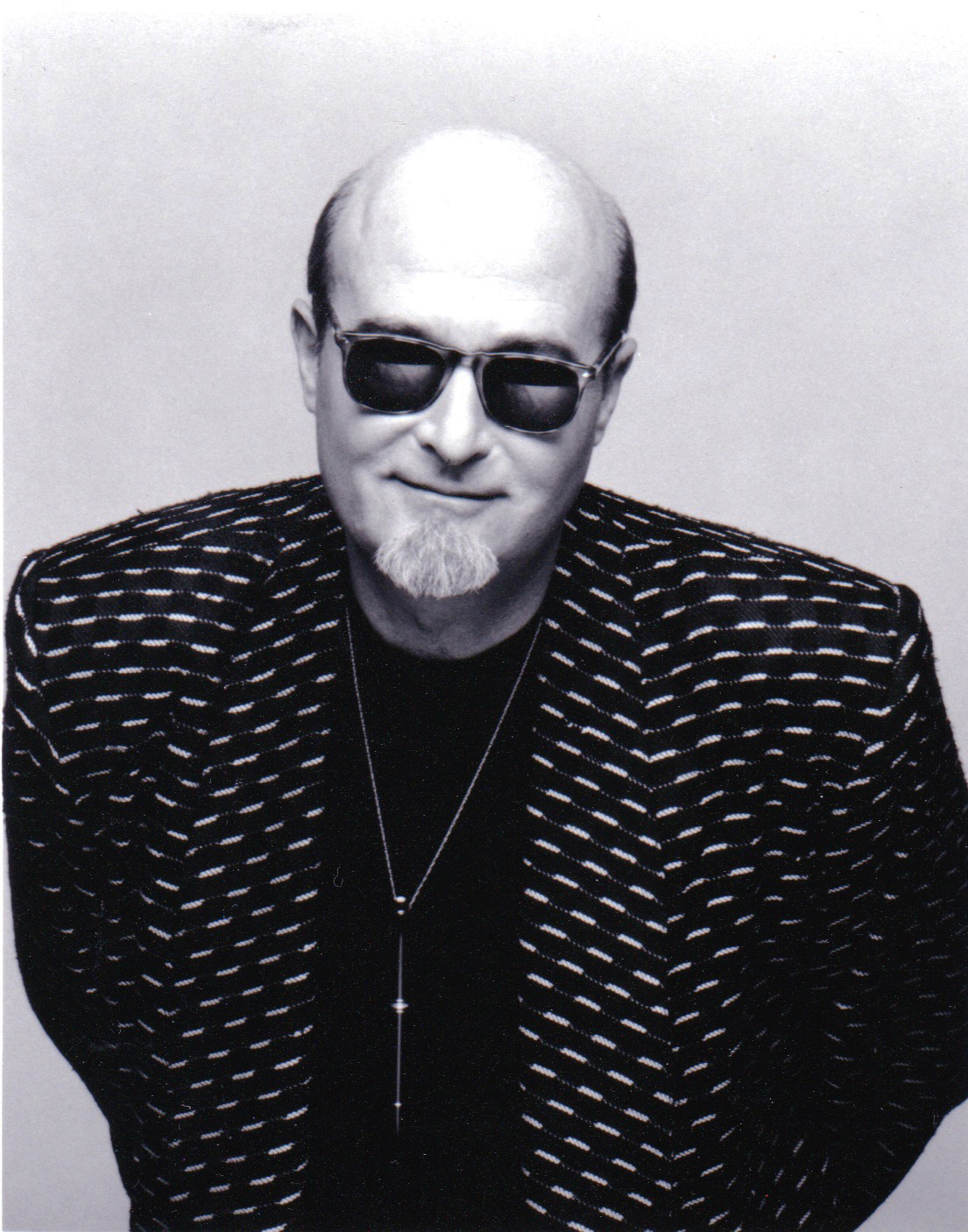 Mr. Bonzai in dark sunglasses and a patterned jacket, black and white portrait.